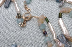 Necklace of freshwater cultured pearls with aquamarine, opal, kyanite and tourmaline on a 9ct gold clasp.