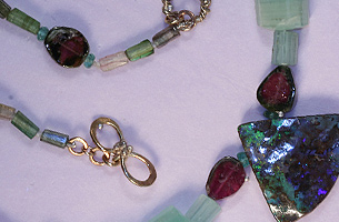 Striking necklace of semi-precious stones mainly tourmaline, but including rough-cut emeralds.  The 9ct handmade clasp is pretty and unusual.  The Australian boulder opal is darkly mysterious with deep flashes of turquoise green and purple.