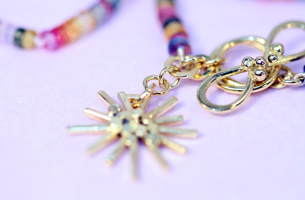 Flower and clasp of 18ct gold surrounded by rainbow coloured, faceted, sapphire beads.  Very pretty!