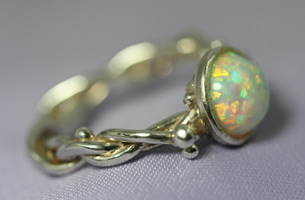 Pretty opal set in a hallmarked silver ring with has a plaited shank.