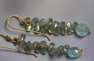 Drop ear-rings of faceted labradorite, almost 4cm. in length , with a final aquamarine stone .
The metal is 9ct, gold .
