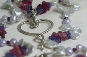Hall-marked sterling silver heart set on a necklet of freshwater cultured pearls , together with semi-precious tourmaline and tanzanite , with a hand-made silver clasp.